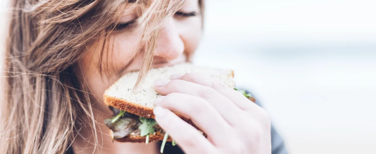 Женщина ест бутерброд